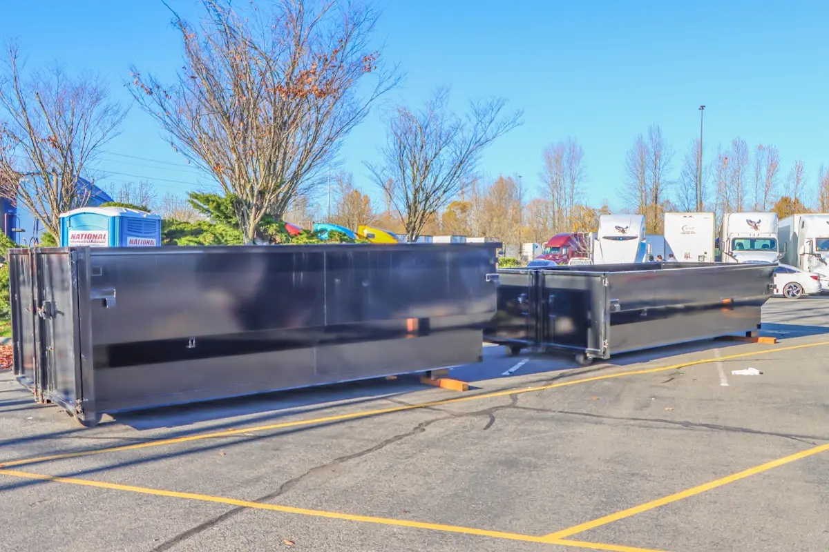 Professional dumpster rental service with roll-off container on residential driveway in Frenchtown